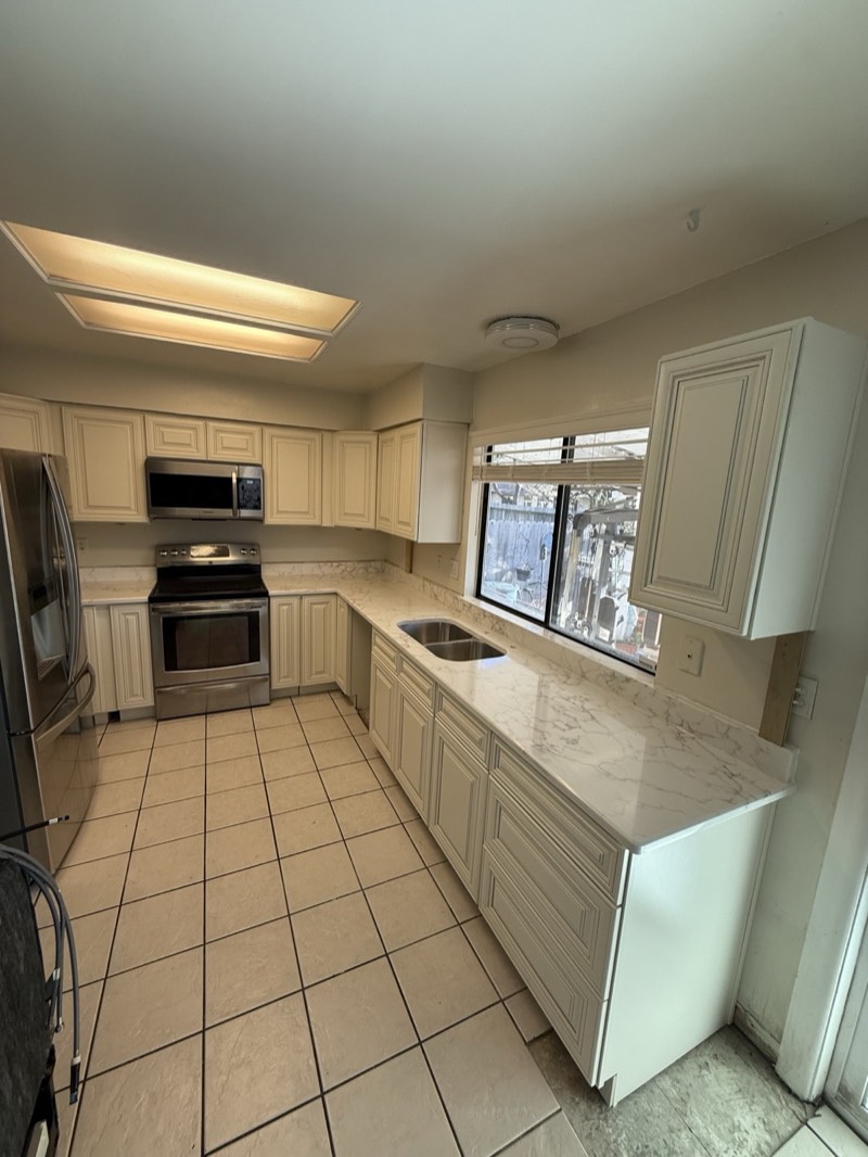 Antique white raised-panel kitchen cabinets by MNK Cabinet in metro Atlanta