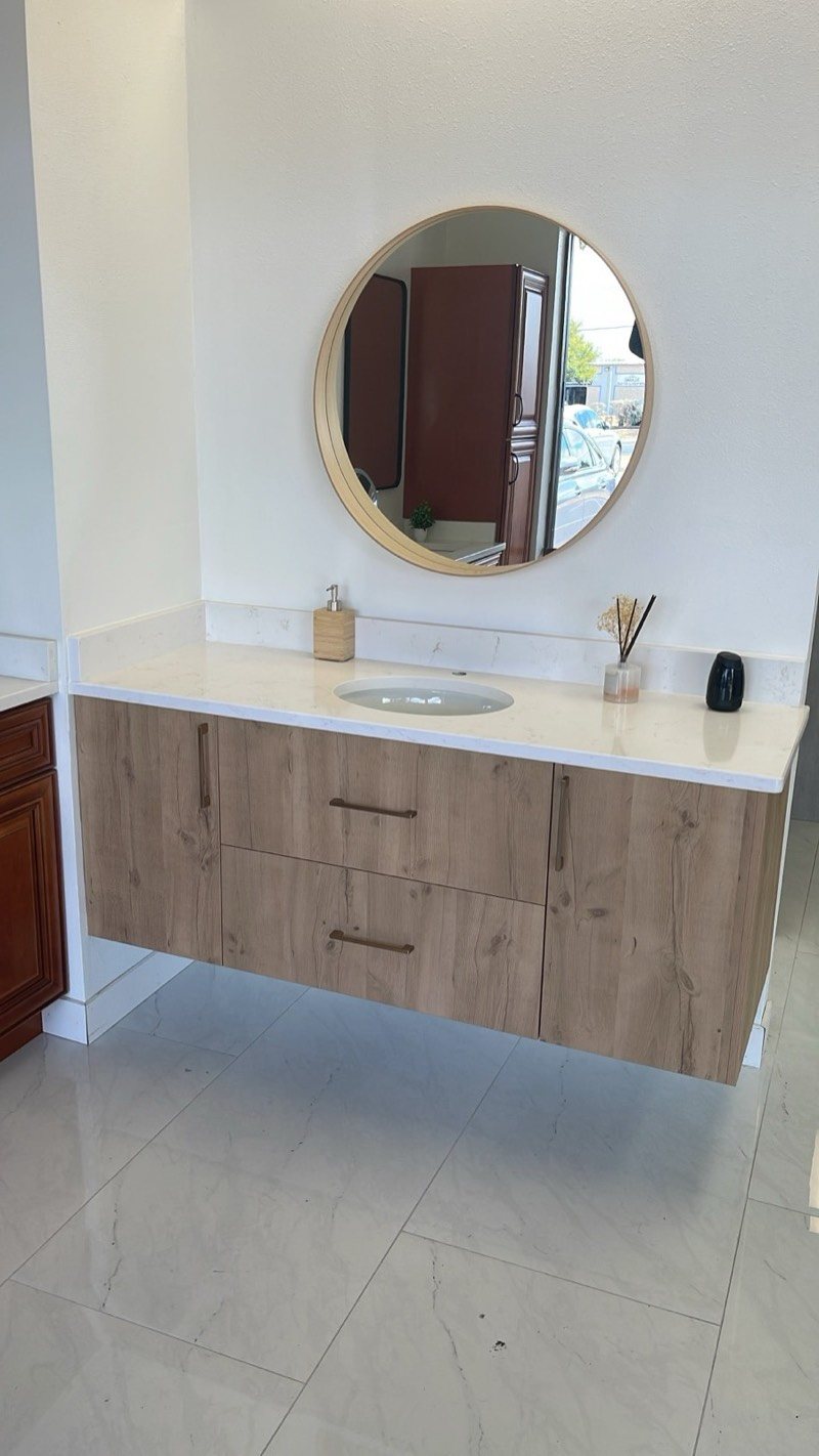 Floating wood-grain bathroom vanity with a round mirror by MNK Cabinet in Atlanta