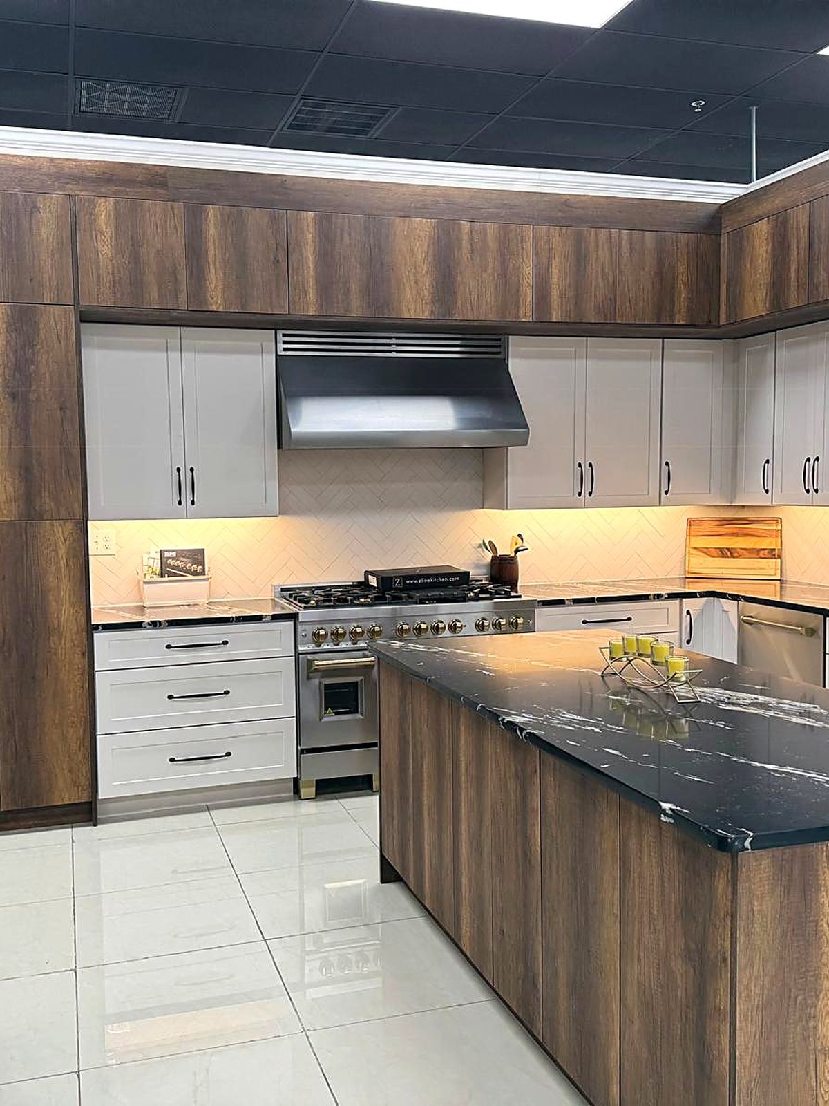 Two-tone kitchen with wood grain cabinets and a dark quartz island at the MNK Cabinet showroom