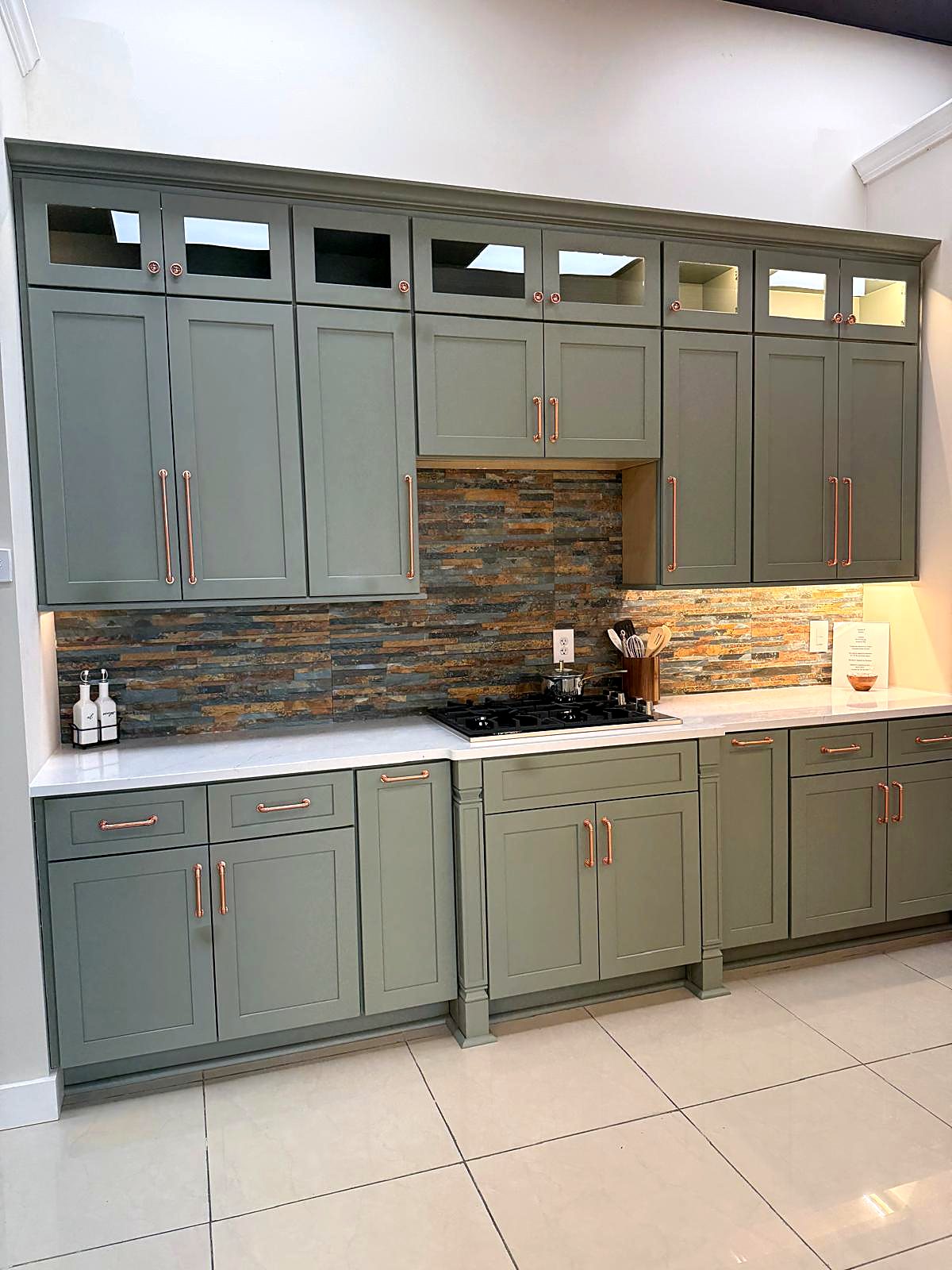 Sage green shaker kitchen cabinets with copper hardware in a metro Atlanta home