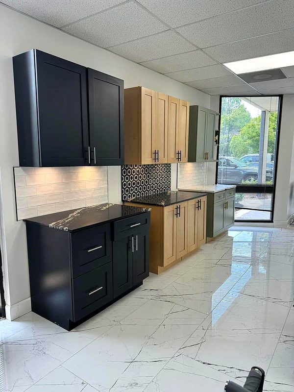 Showroom row of cabinet displays: black/charcoal shaker with black-and-gold marble top — on display at MNK Cabinet's Norcross, GA showroom