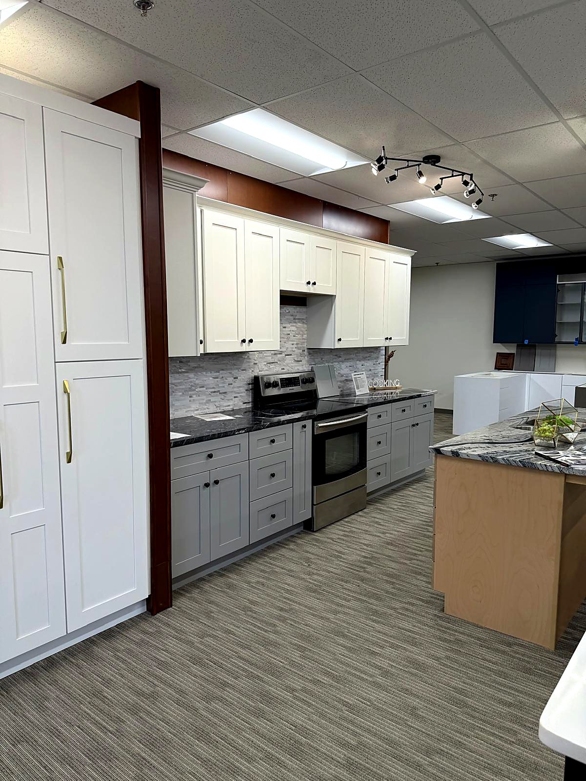 Two-tone white and gray shaker display kitchen at MNK Cabinet's factory-direct cabinet showroom near Atlanta