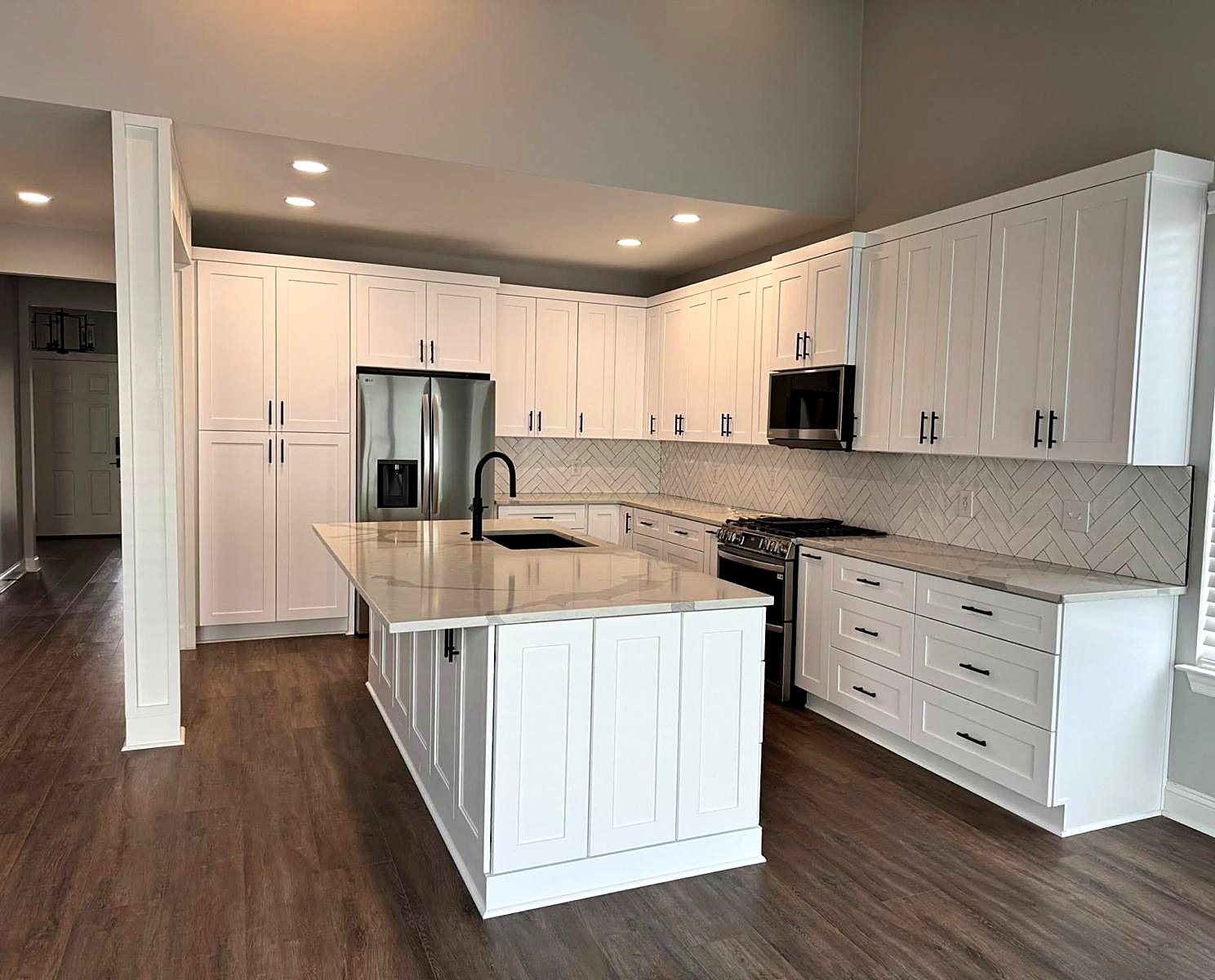 New white shaker kitchen cabinets with a gray island and gray subway tile backsplash in a metro Atlanta home