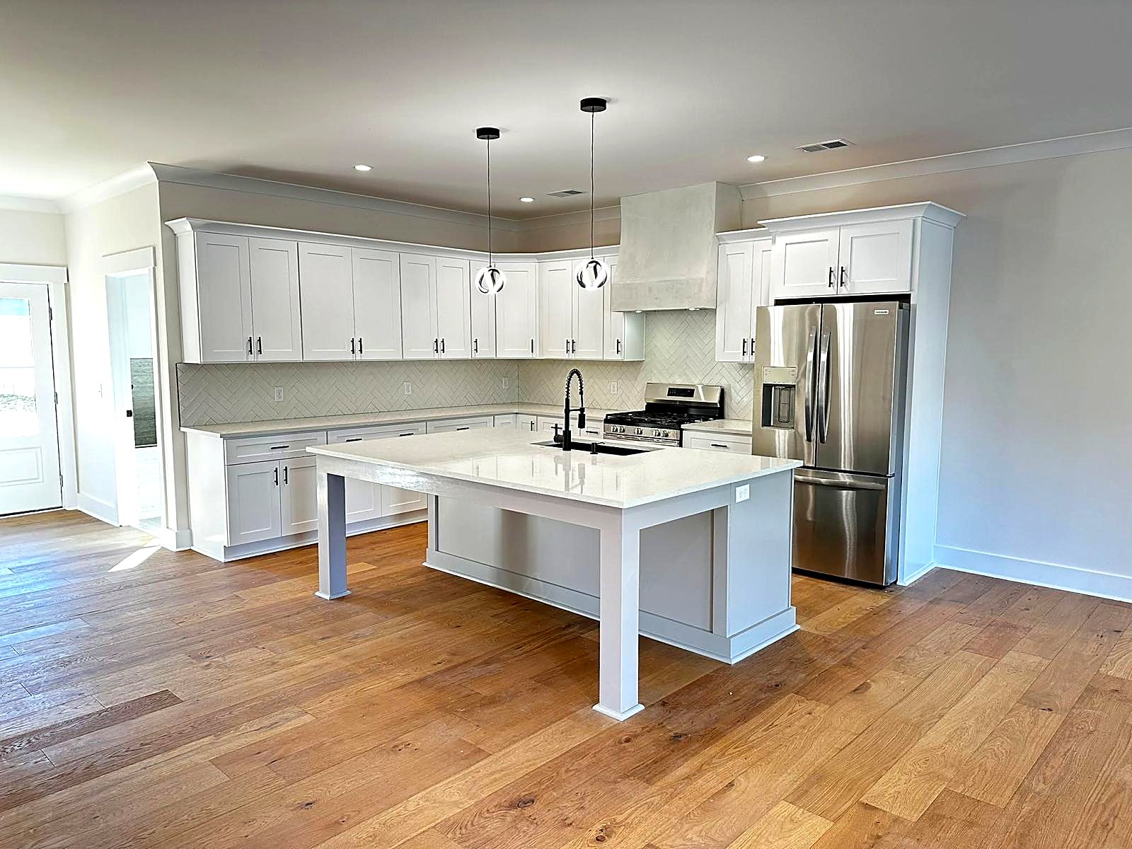 Finished white shaker kitchen with a light gray island built from MNK Cabinet cabinets in metro Atlanta